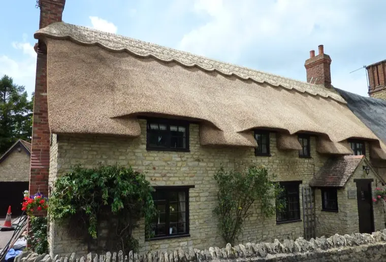 Stone cottage thatched in combed wheat reed