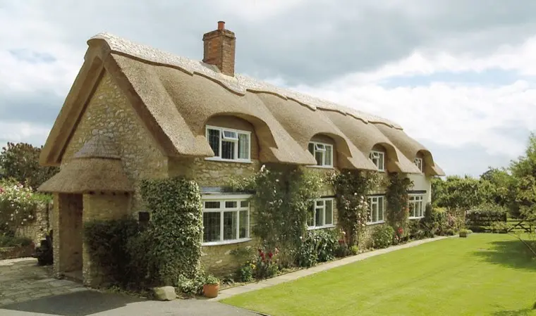 Stone cottage with eyebrow windows and climbing roses