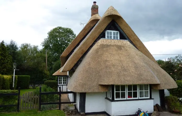 White cottage with a tall thatched gable