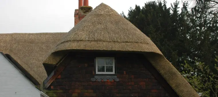 Thatched dormer above a tile-hung gable