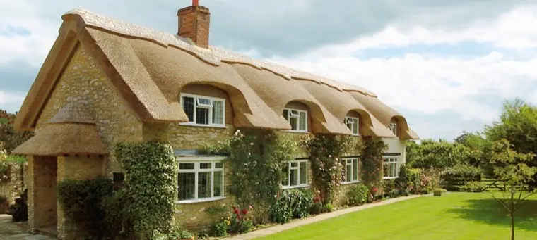 Stone cottage with eyebrow windows and climbing roses